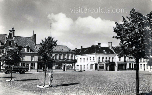 Vue sur les commerces de la Place du Général de Gaulle à Audruicq vers 1960.