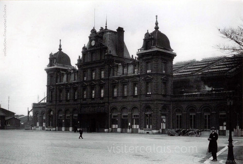 Homme élégamment vêtu devant la gare.