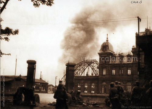 Des soldats regardent la gare en feu. Des soldats regardent la gare en feu.